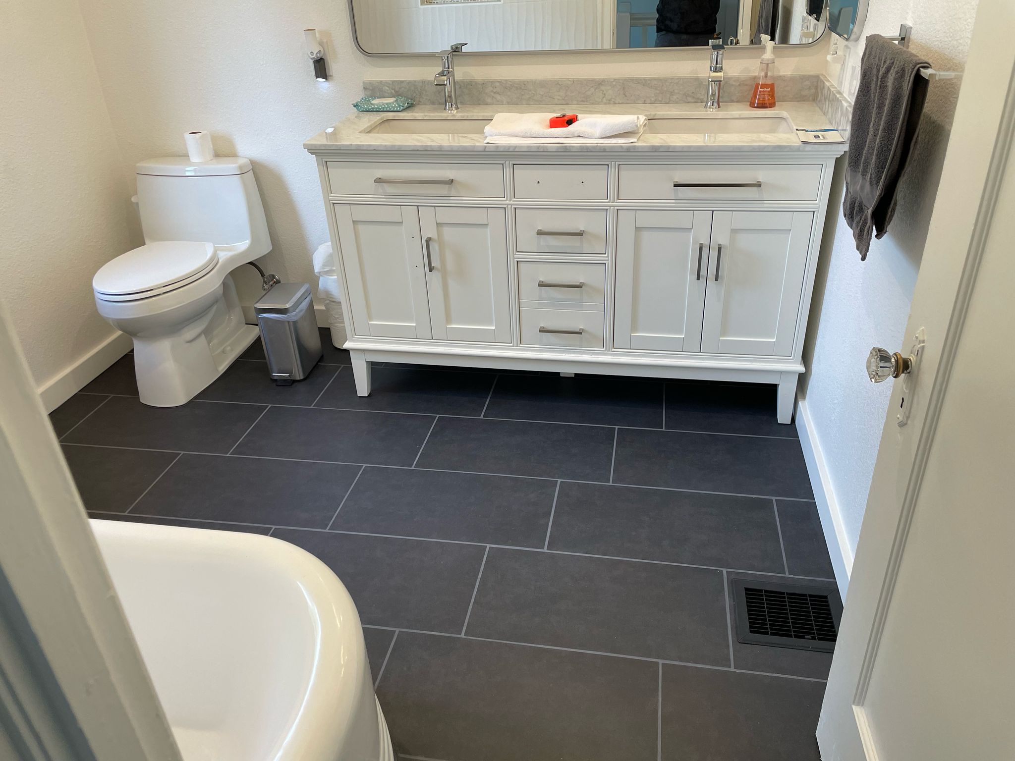 Modern Bathroom with White Vanity and Dark Tile Flooring