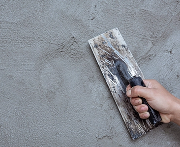 Hand Smoothing Fresh Concrete Surface with Trowel for Home Remodeling