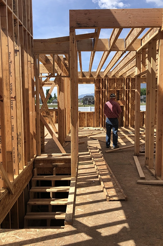 Wooden Framing Structure with a Worker on a Sunny Construction Site
