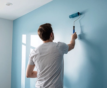 Man Painting a Blue Wall with a Roller Home Remodeling Fairfield CA