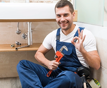 Plumber Smiling and Holding Wrench During Bathroom Remodeling Fairfield CA