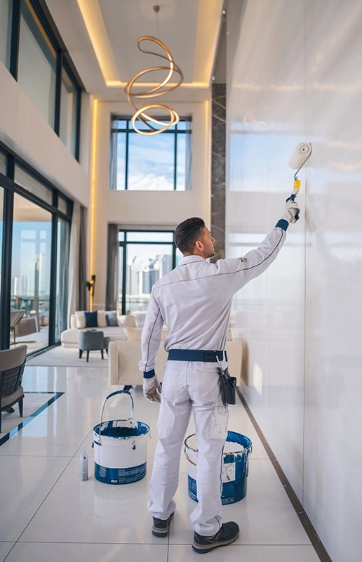 Worker Painting Modern Living Room with Tall Windows in Fairfield CA