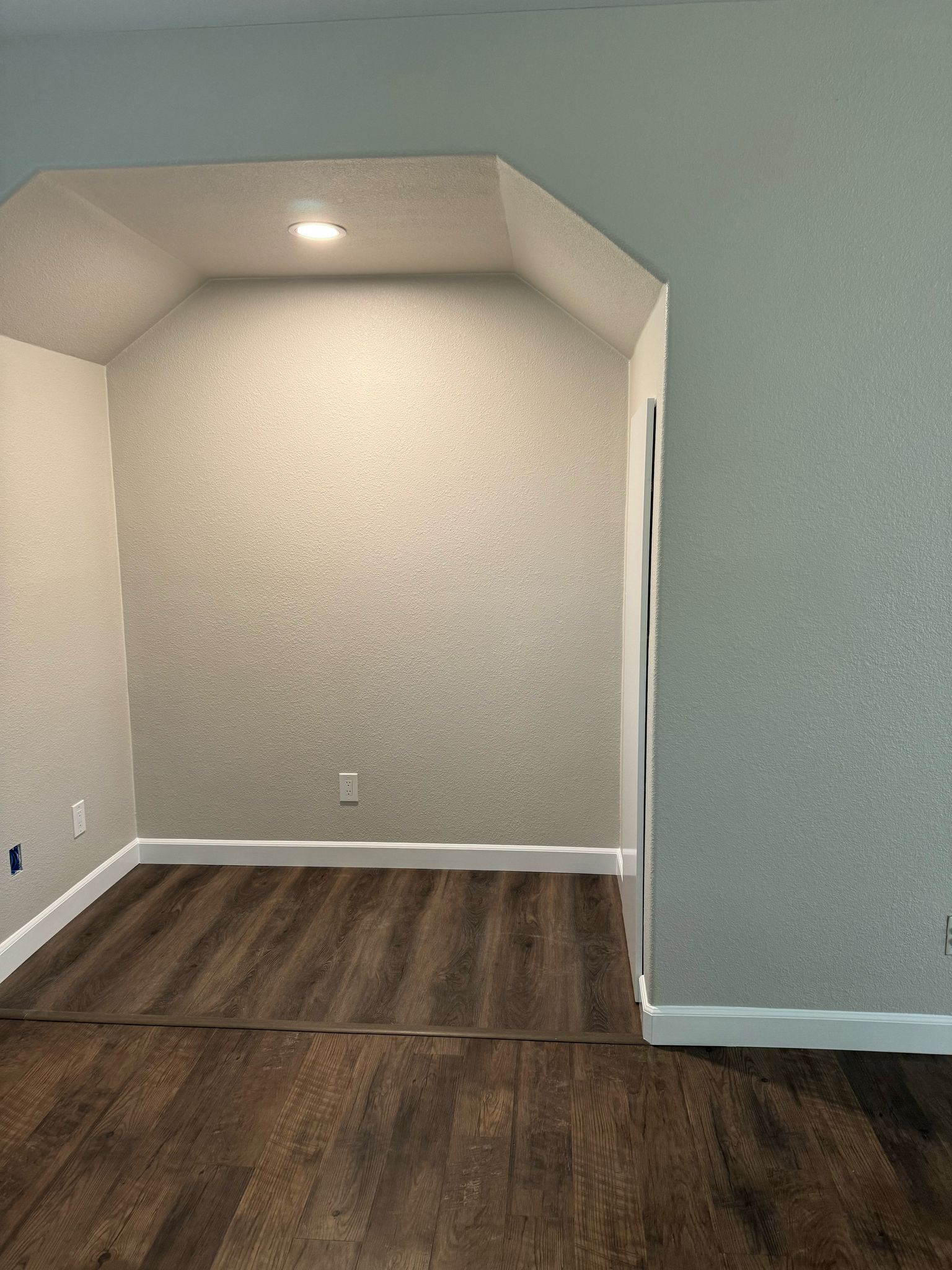 Neutral Painted Room with Recessed Lighting and Dark Wood Floors